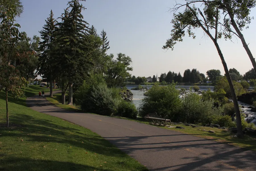 A scenic road flanked by greenery next to Snake River near Idaho Falls